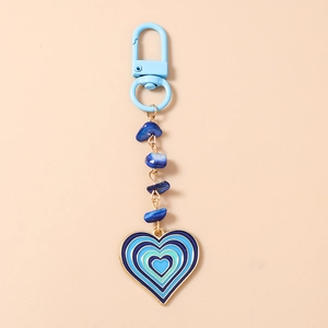 Détail du pendentif cœur en émail avec pierres turquoise et porte-clés perlé bleu