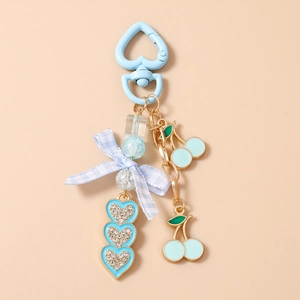 Detail of light blue cherry keychain with checkered bow and rhinestone heart charms