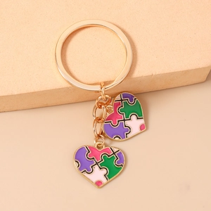 Détail du porte-clés puzzle en cœur avec émail violet et rose sur métal doré
