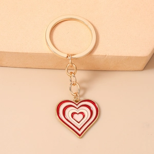 Détail du porte-clés en métal doré en forme de cœur avec émail rose et rouge élégant