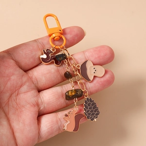 Detail of a squirrel and mushroom charm keychain with natural tiger eye stone beads