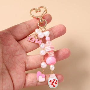 Close-up of star beads, heart charms, and a pink 1314 pendant on a gold keychain
