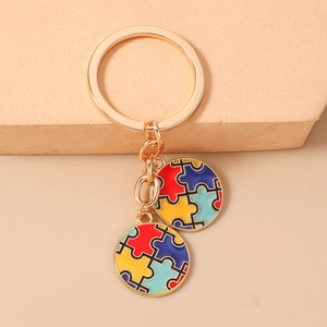Détail des breloques cœur puzzle colorées sur un anneau de porte-clés en métal doré