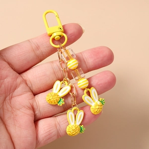 Dettaglio di portachiavi a forma di coniglio ananas giallo con perle di resina e gancio