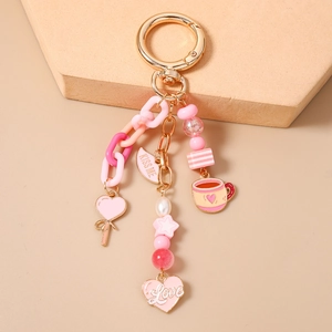 Detail of pink beaded star keychain with heart pendants and gold metal hardware
