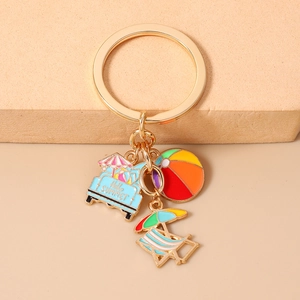 Detail of beach themed keychain with enamel summer charms and gold plated metal hardware