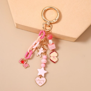 Detail of pink resin chain keychain with golden star and Love heart pendants