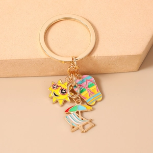 Detailed view of beach themed keychain with sun, flip-flop and beach chair enamel charms