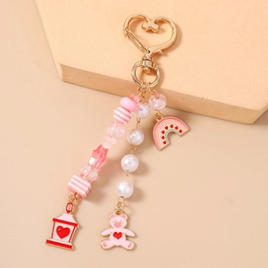 Detailed shot of pink heart bear keychain with rainbow charms and golden heart clasp
