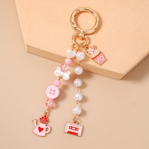 Detailed close-up of beaded star keychain with pink tape and cupcake charms for bags