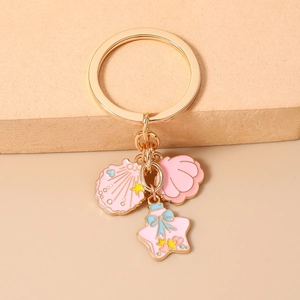 Close-up of ocean themed keychain with pink shell charms and starfish bottle pendant