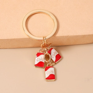 Detail of gold metal keychain featuring three red enamel miniature soda can pendants