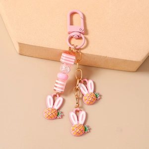 Portachiavi con ciondoli coniglio-ananas rosa, perle glitterate e gancio dorato