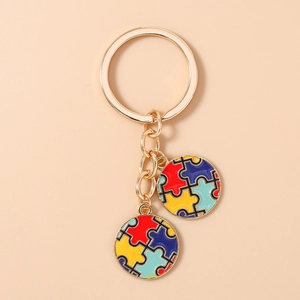 Gros plan du porte-clés doré avec pendentifs cœur puzzle colorés et finition en émail
