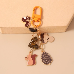 Detailed close-up of squirrel, mushroom, and pinecone charms with tiger eye stones