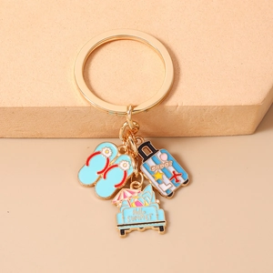 Detail of beach keychain with summer flip-flops, suitcase, and car charms on gold ring