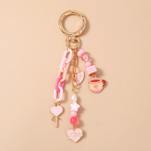 Detail of pink beaded keychain with heart pendant, coffee cup charm and gold metal ring