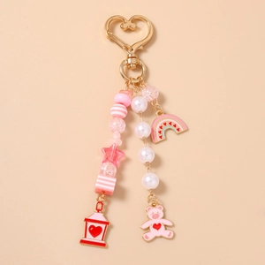 Detailed view of pink bear beaded keychain with gold heart clasp and rainbow charms