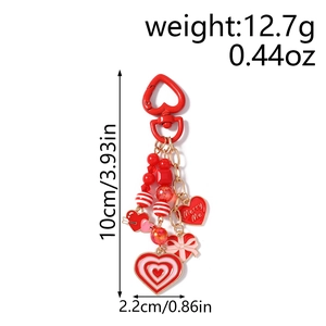 Detailed view of red heart keychain with beads and Merry Me enamel charms
