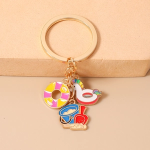 Detail of beach keychain with colorful enamel swim ring, swan float and sand bucket charms