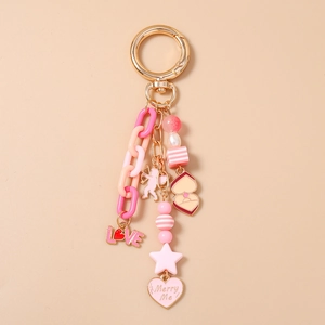 Detail of pink beaded star keychain with LOVE charm and Merry Me heart pendant