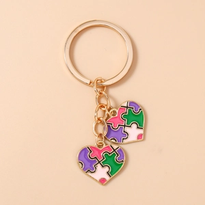 Détail d'un porte-clés puzzle en forme de cœur avec émail coloré sur métal doré poli