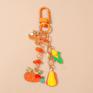Detail of autumn-themed enamel squirrel pumpkin and corn keychain with lobster clasp