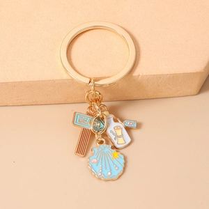 Detail of beach theme gold keychain with enamel starfish, shell and drift bottle charms
