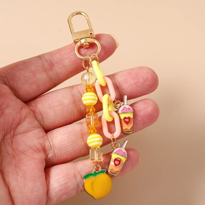 Détail du porte-clés avec breloques thé au lait, chaîne rose et perles multicolores