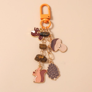Detail of forest-themed keychain with squirrel, mushroom charms and natural tiger eye stones