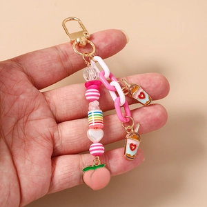 Vue détaillée d'un porte-clés à grosse chaîne avec charms pêche et tasse de café