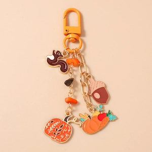 Detail of autumn pumpkin and squirrel keychain with golden lobster clasp and acorn charm