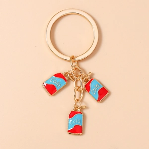 Detail of golden alloy keychain with three colorful miniature cola can charms