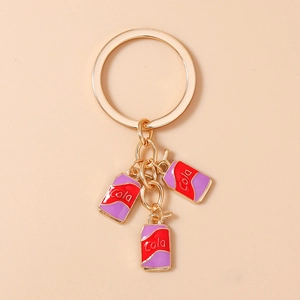 Detail of golden keychain with red and purple enamel cola can charms and metal ring