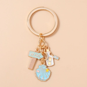 Detail of beach themed keychain featuring enamel starfish shell and message bottle charms