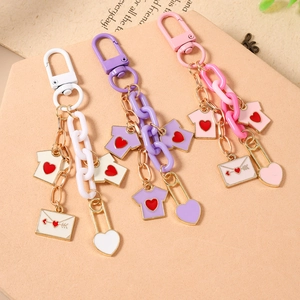 Fashionable thick chain heart keychains in white, purple, and pink on a display stand