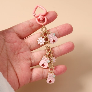 Detailed view of pink lucky cat charms with heart-shaped buckle and gold chain