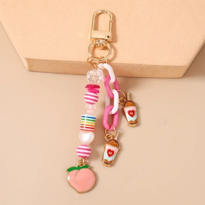 Détail du pendentif pêche rose et de la chaîne en acrylique sur un support d'exposition