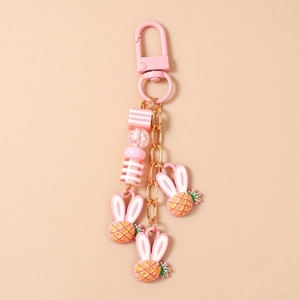 Dettaglio del portachiavi rosa con ciondoli ananas in resina e perle decorative