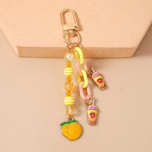Vue détaillée des breloques pêche et thé à bulles avec chaîne en plastique et fermoir doré