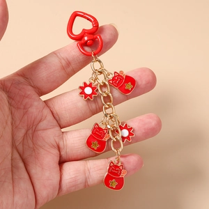 Detail of red lucky cat keychain with heart clasp and gold enamel star charms