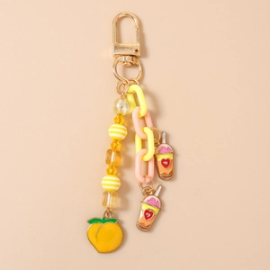 Détail de pendentifs pêche et thé au lait avec chaîne jaune sur le porte-clés