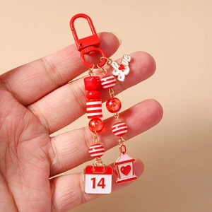 Detailed view of Valentine's keychain with red beads, love pendant and Feb 14 calendar