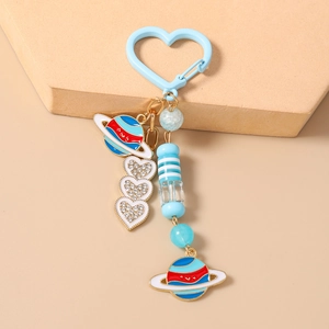 Détail du porte-clés coeur avec breloques planètes en émail et perles de coeur en cristal