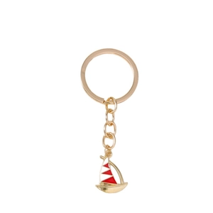 Golden alloy sailboat keychain with red and white enamel sails on white background