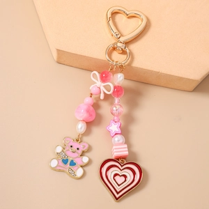 Detail of pink resin bear and heart charms with gold star beads on a stylish keychain