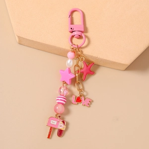 Detail of pink beaded keychain with starfish, golden stars and love mailbox pendants