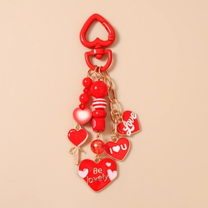 Detail of red heart keychain with beaded charms and 'Love' pendants on warm background