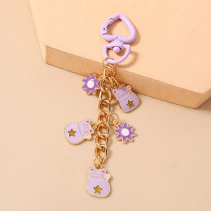Close-up of purple lucky cat keychain with heart-shaped clasp and floral charms