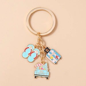 Detailed shot of gold-tone summer keychain with flip-flop, suitcase, and surf car charms